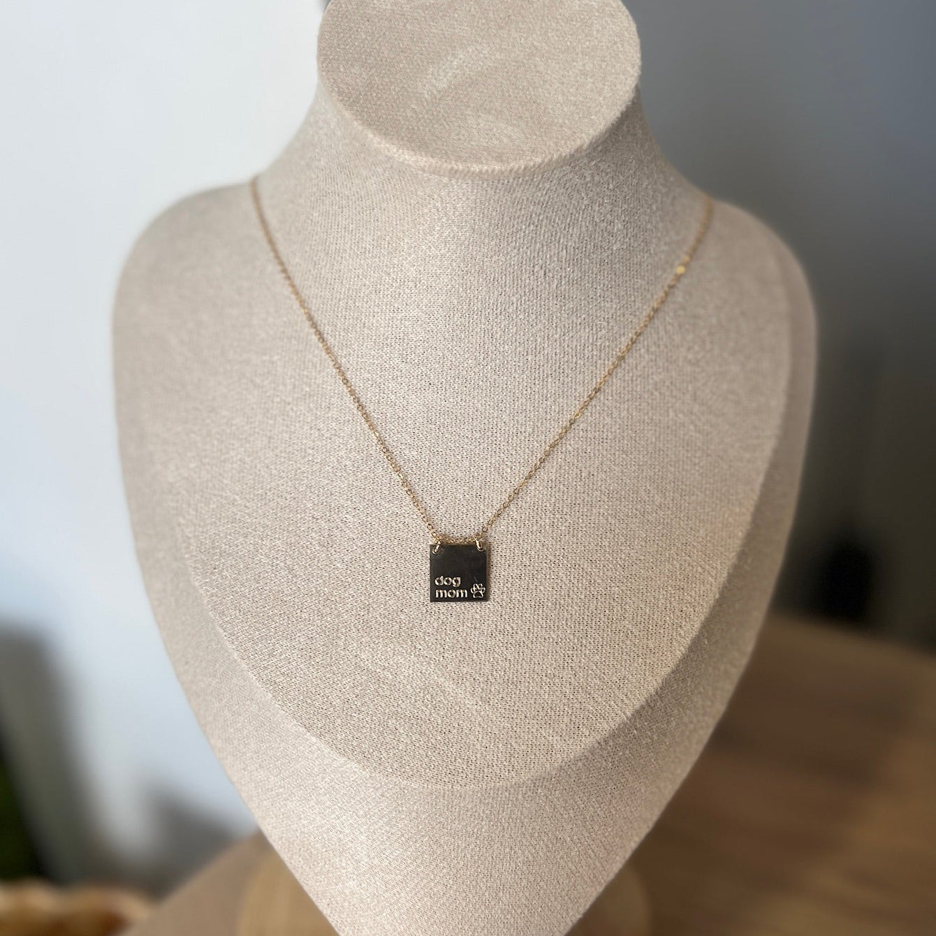 Necklace with a pendant on a mannequin bust against a neutral background